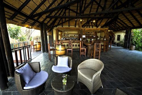 a patio with chairs and tables and a bar at Gondwana Namushasha River Lodge in Kongola