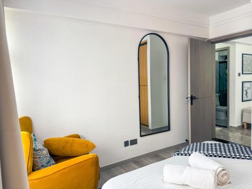a bedroom with a yellow couch and a mirror at Getaways homes in Nairobi
