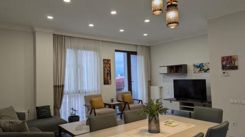 a living room with a table and a television at Your home in the heart of Batumi, sea in 8th minute in Batumi