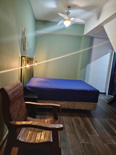 - une chambre avec un lit, une chaise et un ventilateur de plafond dans l'établissement Villa's Serena, à Bertioga