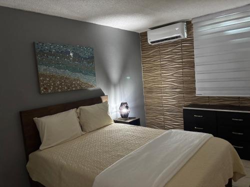 a bedroom with a bed and a window with a air conditioner at Private apartment near sju Solar Battery in Carolina