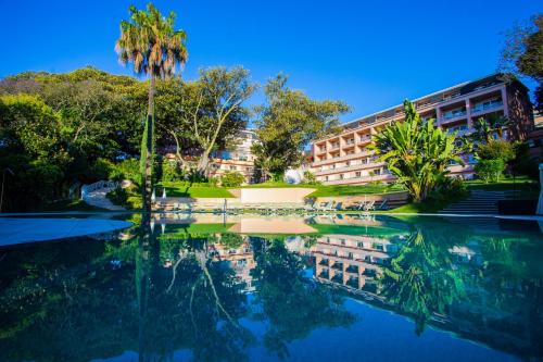 a building with a reflection in a pool of water at Olissippo Lapa Palace – The Leading Hotels of the World in Lisbon