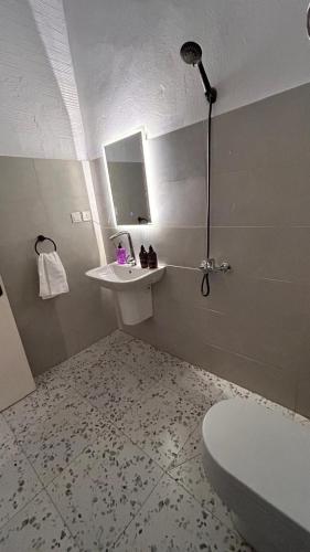 ein Badezimmer mit einer weißen Toilette und einem Waschbecken in der Unterkunft شقة حي البوادي in Dschidda
