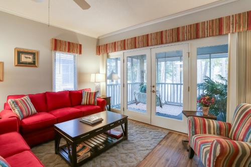 a living room with a red couch and a table at Swim, Golf and Relax Myrtle Beach Unit in Tidewater in North Myrtle Beach