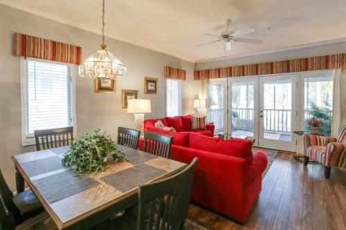 a living room with a red couch and a table at Swim, Golf and Relax Myrtle Beach Unit in Tidewater in North Myrtle Beach