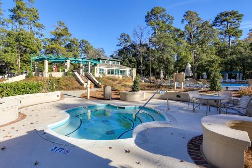 a pool with a table and chairs and a house at Swim, Golf and Relax Myrtle Beach Unit in Tidewater in North Myrtle Beach