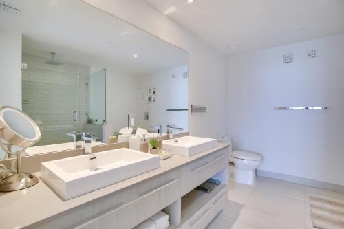 a white bathroom with two sinks and a mirror at Upscale Condo w/ Pool Access in Hyde Beach House! in Hollywood