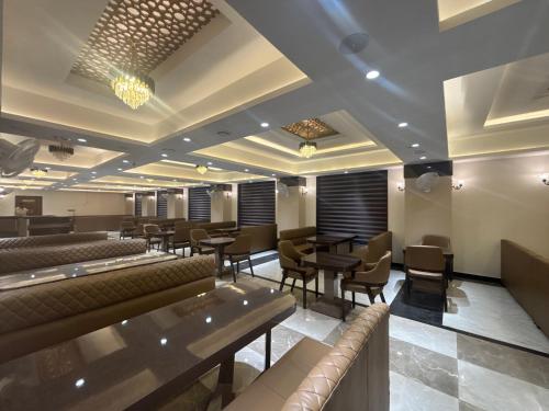 a restaurant with couches and tables and chairs at Hotel Amyra in Kota