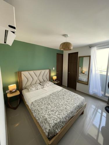 a bedroom with a bed and a green wall at Comfort and spectacular views in Barranquilla! in Barranquilla