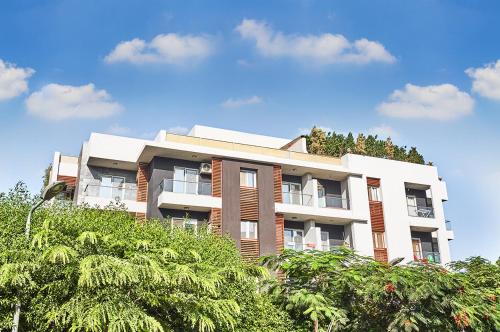 een hoog gebouw met bomen ervoor bij Modern chic rooftop studio in Sheikh Zayed