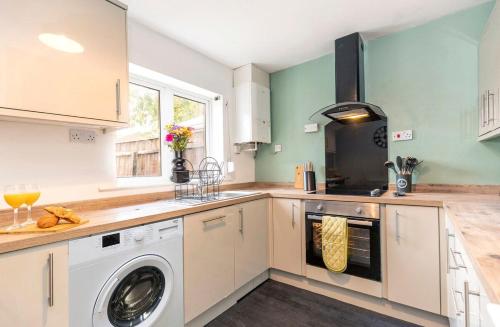 a kitchen with a washer and dryer in it at Cherry House in Durham