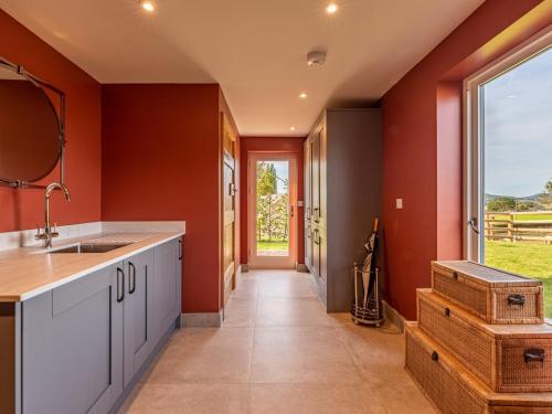 a kitchen with red walls and a large window at 3 Bed in Madley 83659 in Madley