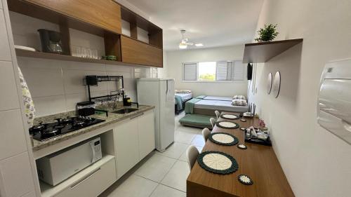 eine Küche mit einem langen Tisch in einer Küche in der Unterkunft Morada da Fé I 300 m da Canção Nova Cond Da fé in Cachoeira Paulista