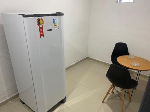 a refrigerator in a room with a table and two chairs at Apartamento espaçoso e bem localizado in Boa Vista