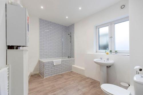 a white bathroom with a toilet and a sink at *Discounts/Contractors/WIFI/Free Parking/Smart TV in Durham