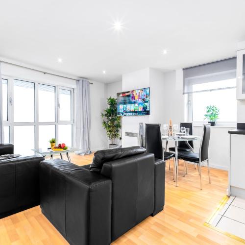 ein Wohnzimmer mit einer schwarzen Couch und einem Tisch in der Unterkunft Stylish Two Bed Apartment - Speed Wi-Fi - Smart Tv - Parking 201MH in Birmingham