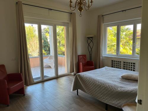 ein Schlafzimmer mit einem Bett und zwei Glasschiebetüren in der Unterkunft Vista Verde - Villla Giulia 5 min loopafstand tot het meer in Porto Valtravaglia
