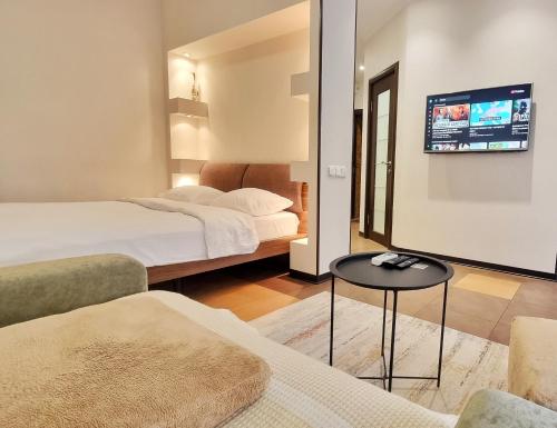 una habitación de hotel con dos camas y un televisor en Kyiv Center Romantic Apartment, en Kiev