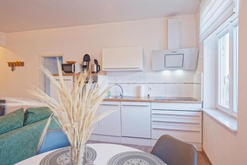 a kitchen with white cabinets and a table at Modern family apartment in Bamberg in Bamberg
