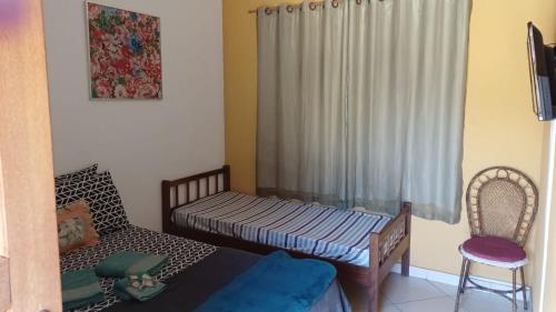 a small room with a bed and a chair at Barão do Vale in Itaipava