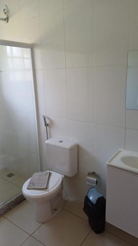 a white bathroom with a toilet and a sink at Barão do Vale in Itaipava
