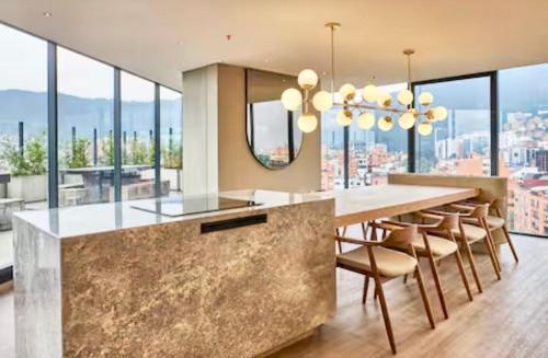 a kitchen with a large table with chairs and windows at Luxury Loft in Bogotá
