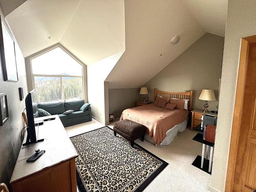 1 dormitorio en el ático con 1 cama y 1 sofá en Forest Park 3 bed 4 Bath Twnhm HTJM, en Silverthorne
