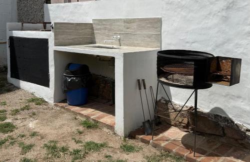 a kitchen sink and a trash can next to a building at Tres Soles in Salsipuedes