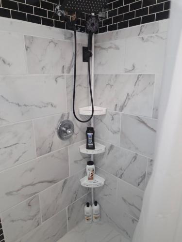a bathroom with a shower with white marble tiles at Mellow Yellow in Jackson