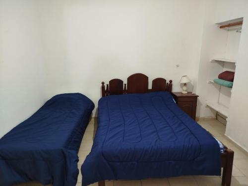 a bedroom with two beds with blue sheets and a table at Tote Esquina in Esquina