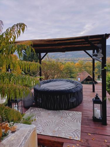 ナジュマロシュにあるFecskefészek vendégházの木製デッキに座る大型タイヤ