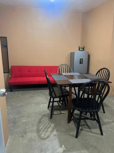 a red couch in a room with a table and chairs at Casa de chapis in Ensenada