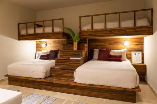 two beds in a room with two bunk beds at Los Veneros Punta de Mita - Pacific Tower in Punta Mita