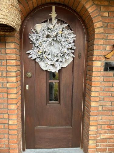 a brown door with a wreath on it at De Bijenkorf in Damme