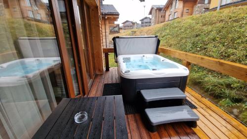 a bath tub sitting on a deck next to a pool at Apartment ABAKUS with jacuzzi & sauna in Demanovska Dolina