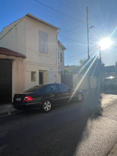 une voiture noire garée sur le côté d'une rue dans l'établissement Chez Theo, à Marseille