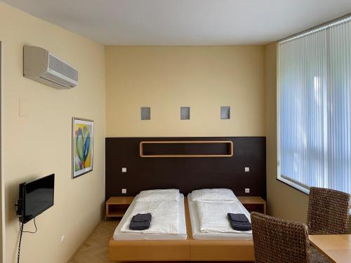 a bedroom with a bed and a desk and a tv at Penzion BránaBeskyd in Frýdlant nad Ostravicí