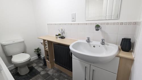 a bathroom with a white sink and a toilet at Modern Four Bedroom House near Attractions, Stadium, Town Centre, Parks and Lake - Sky n Netflix - Convenient Transport in Burnley
