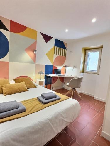 a bedroom with a large bed and a desk at Le chateau de ma mère- climatisé -duplex- 4 personnes in Aubagne