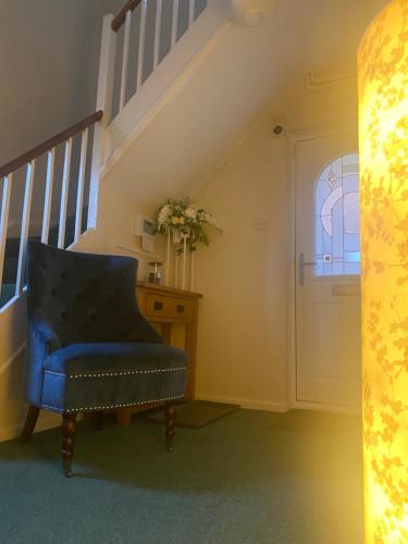 a blue chair in a room with a staircase at Lincoln Cathedral Retreat in Scampton