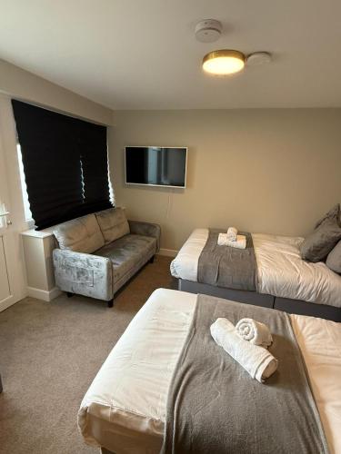 a hotel room with two beds and a flat screen tv at Modern Studio London Near Hospital in Thornton Heath
