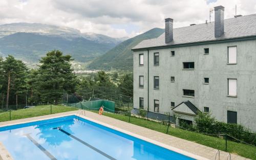 a large swimming pool in front of a building at Casa Los Altos de Santiago in Villanúa