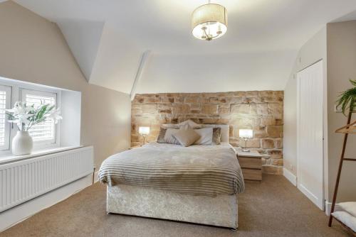 a bedroom with a bed and a stone wall at 3 Bed in Mealsgate oc-e33626 in Mealsgate