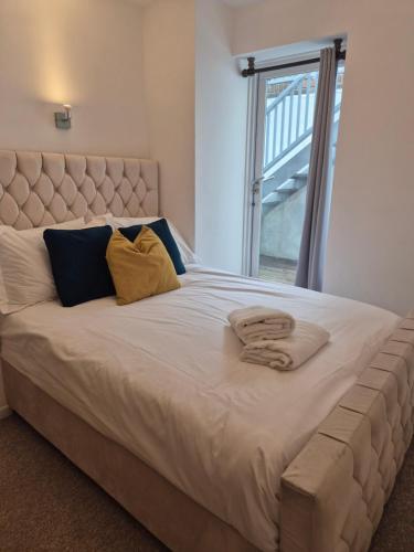 un grand lit blanc avec deux oreillers et une fenêtre dans l'établissement Eco House Brighton & Hove, à Brighton et Hove