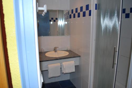 a bathroom with a sink and a mirror at Le Richelieu in Le Boulou