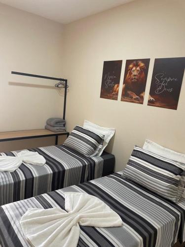 two beds sitting next to each other in a room at Apartamento solteiro sinop 9 in Sinop