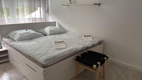 a bed with two pillows and a chair in a bedroom at Panorama-180-Grad in Kitzingen