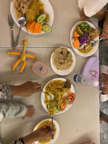 une table avec des assiettes de nourriture dessus dans l'établissement Mahalli Balad Sayt Heritage Inn, à Bilād Sayt