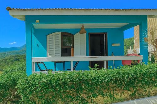 une maison bleue avec terrasse couverte sur une colline dans l'établissement Chalé em Penedo - Linda Vista Condomínio, à Itatiaia