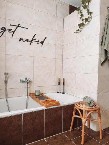 een badkamer met een bad en een kruk bij Ella House in Lingen
